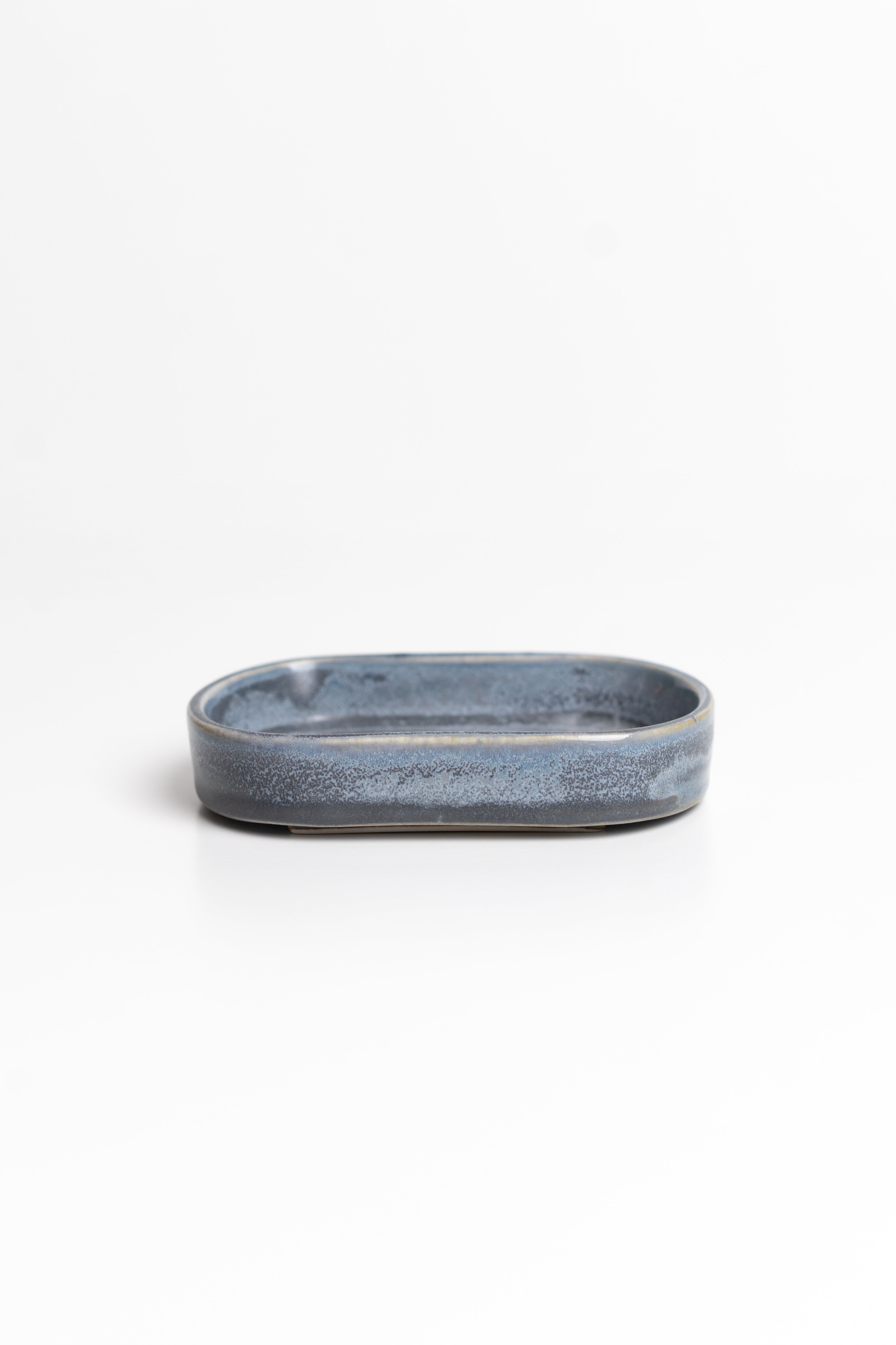Oval blue ceramic dish on a white background