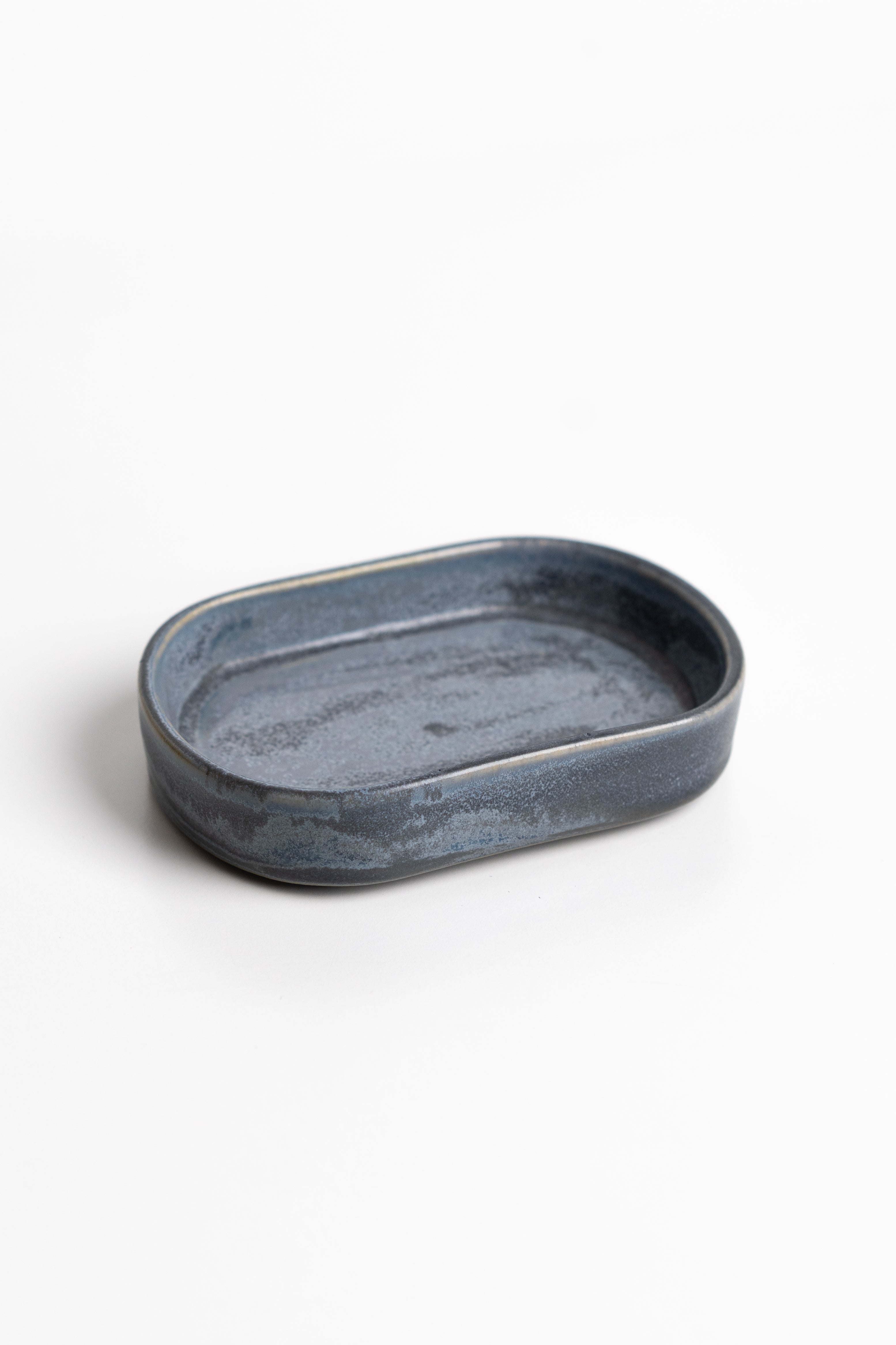 Oval blue ceramic dish on a white background