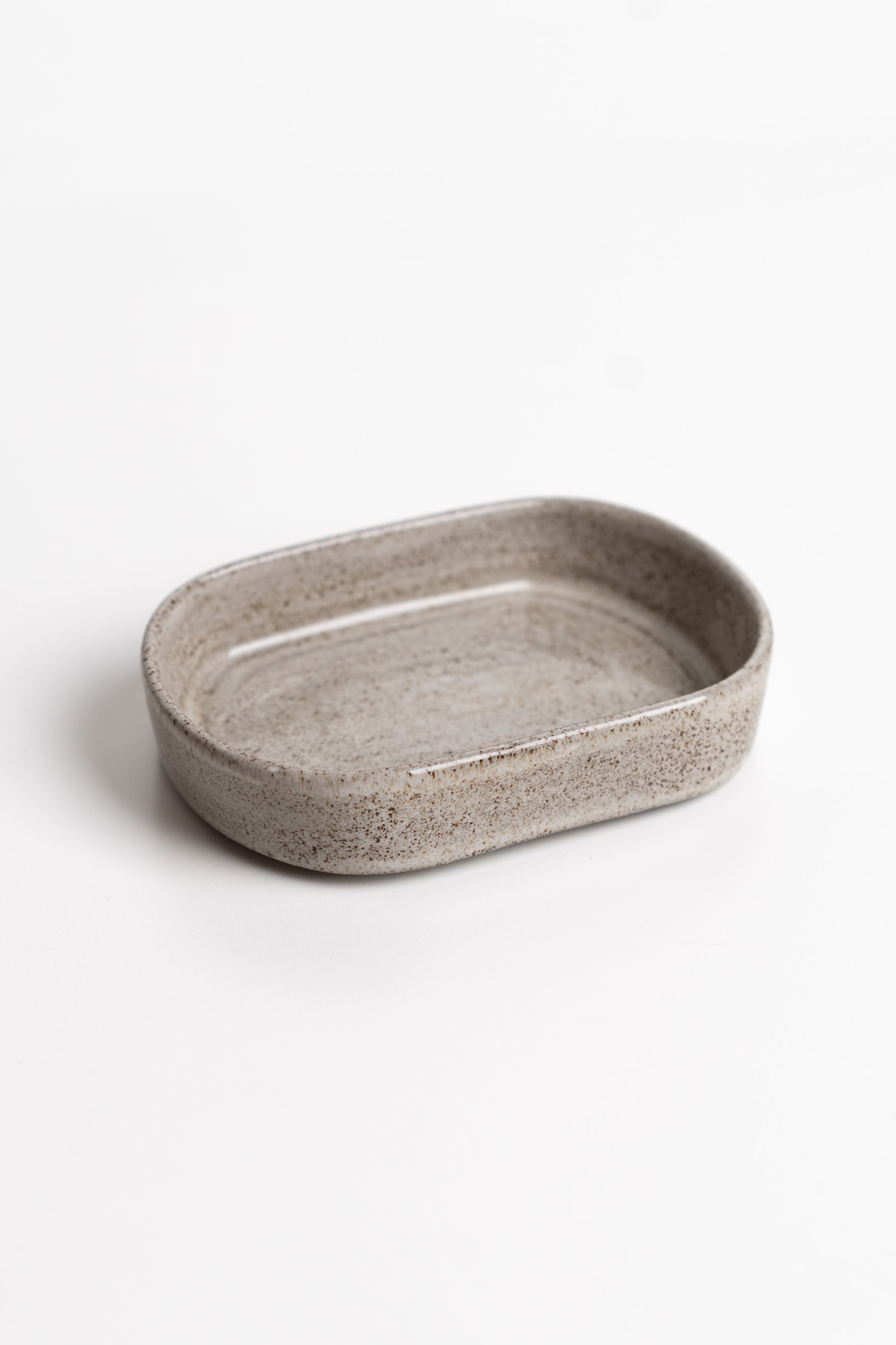 Oval ceramic dish with a textured surface on a white background