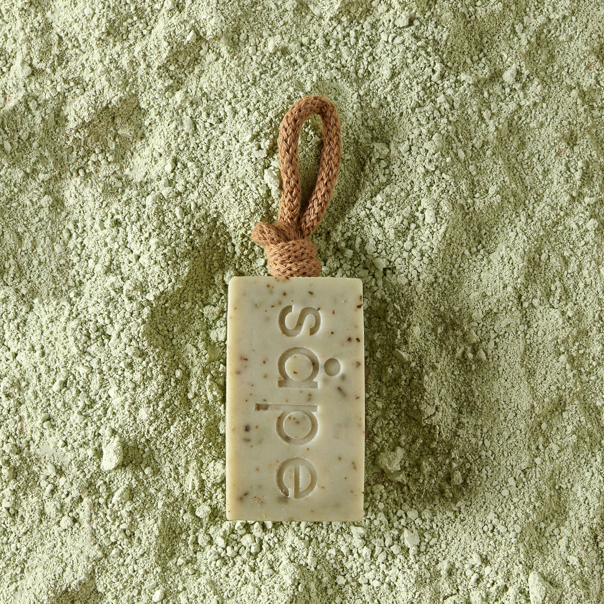 Frisk soap laying on green clay – energising cold-process soap for oily skin