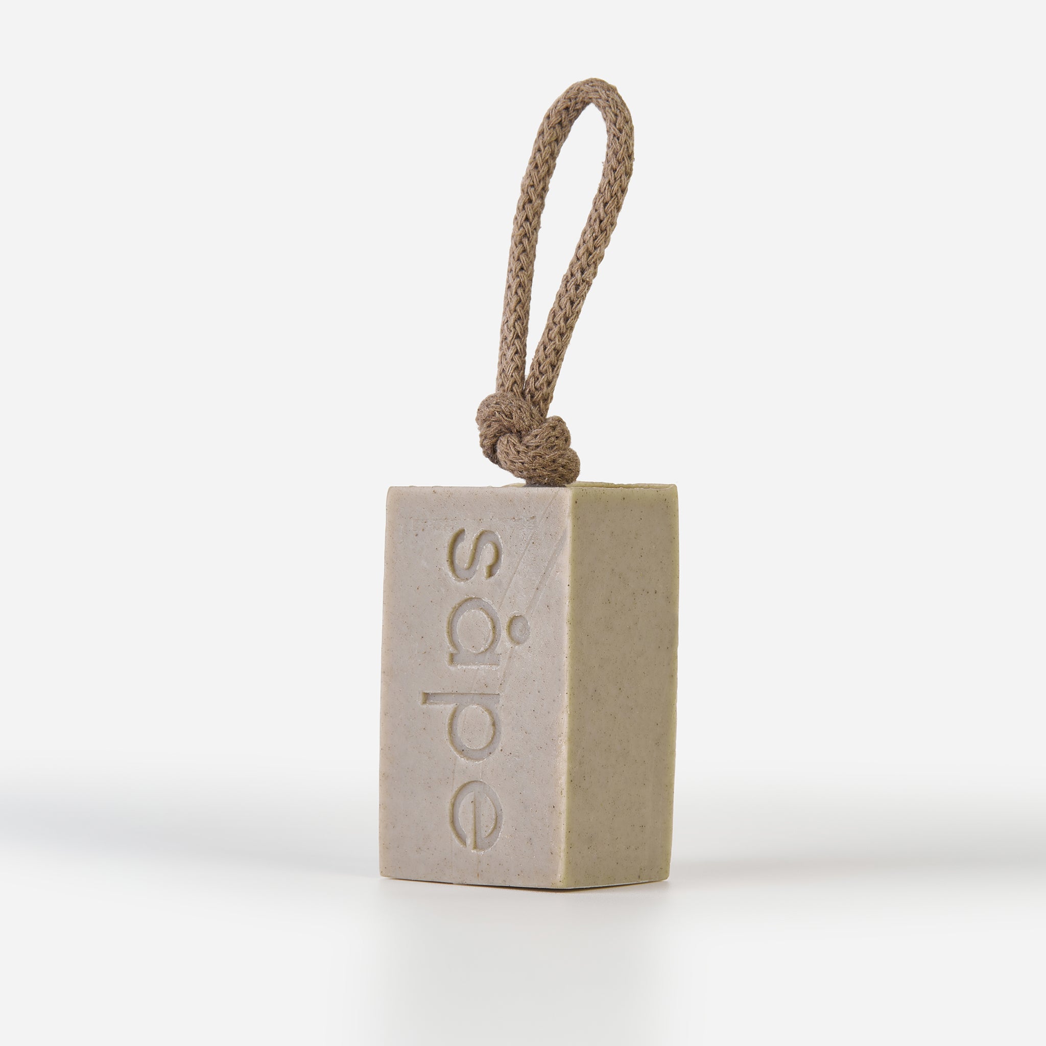 Side view of Bris Dead Sea clay soap on a rope with visible rope texture