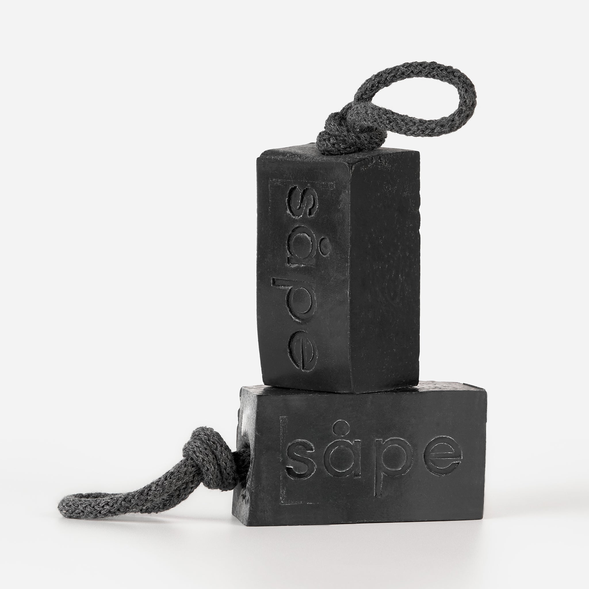 Stacked Myrk charcoal soap bars showing embossed Såpe branding – cold-process soap