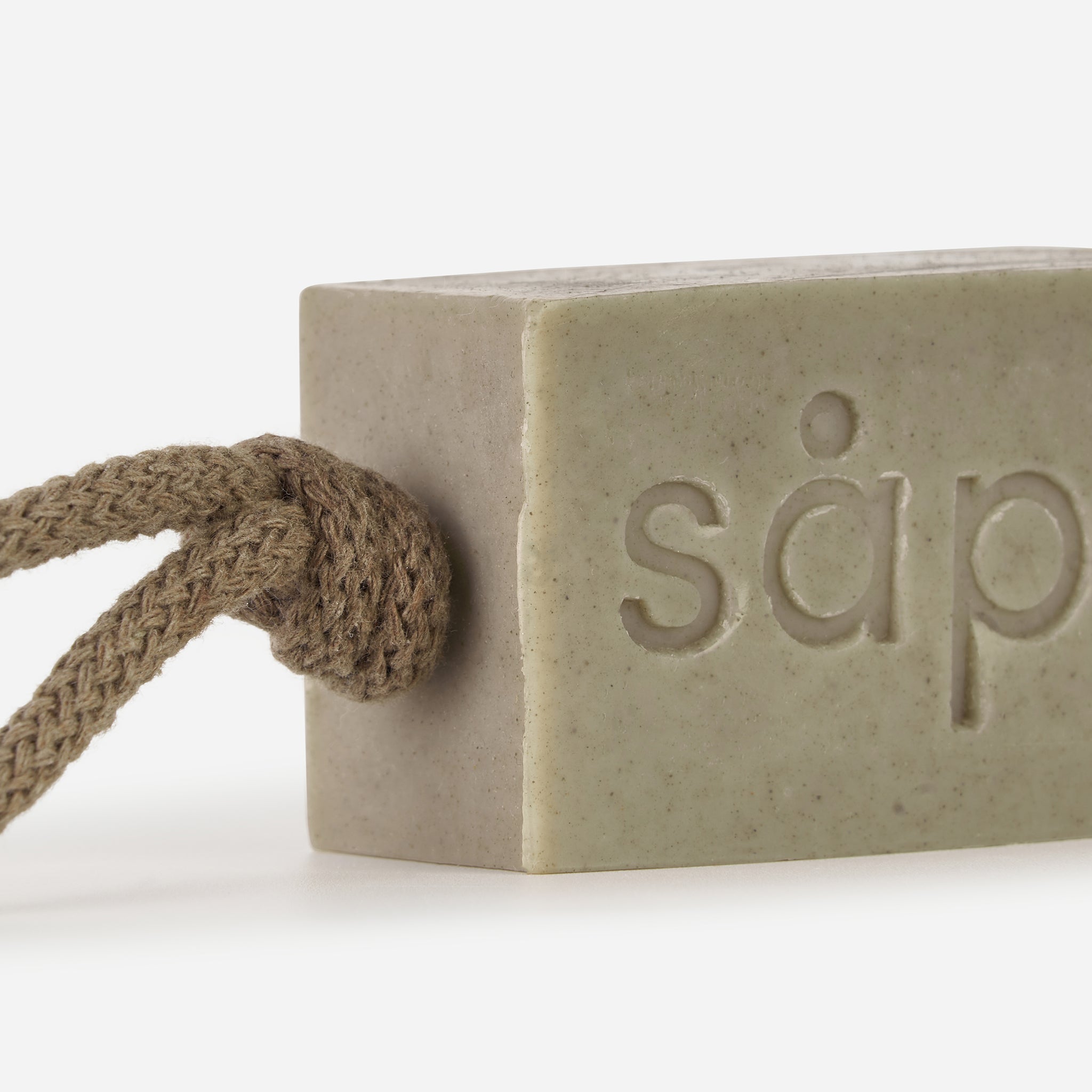 Close-up of Bris handmade soap showing natural clay texture and rope detail