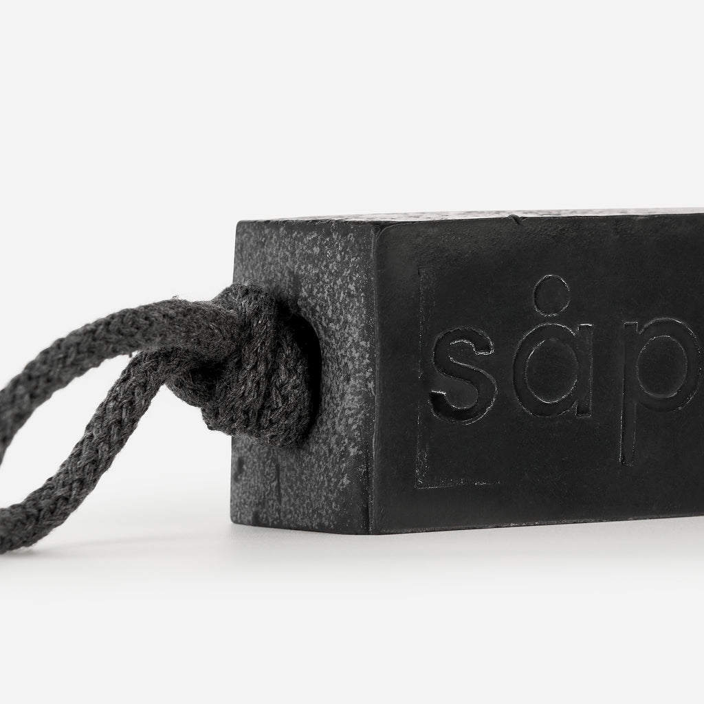 Close-up of Myrk handmade charcoal soap showing activated charcoal and rope detail