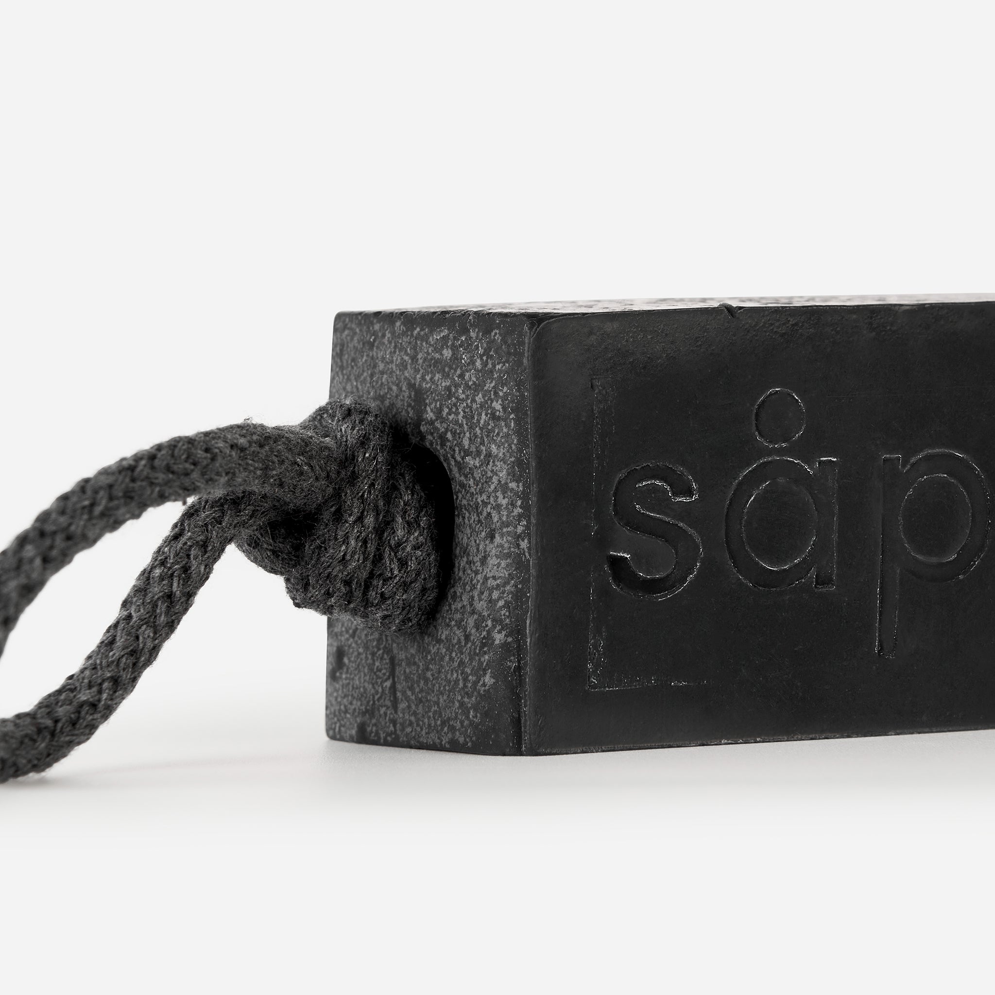 Close-up of Myrk handmade charcoal soap showing activated charcoal and rope detail