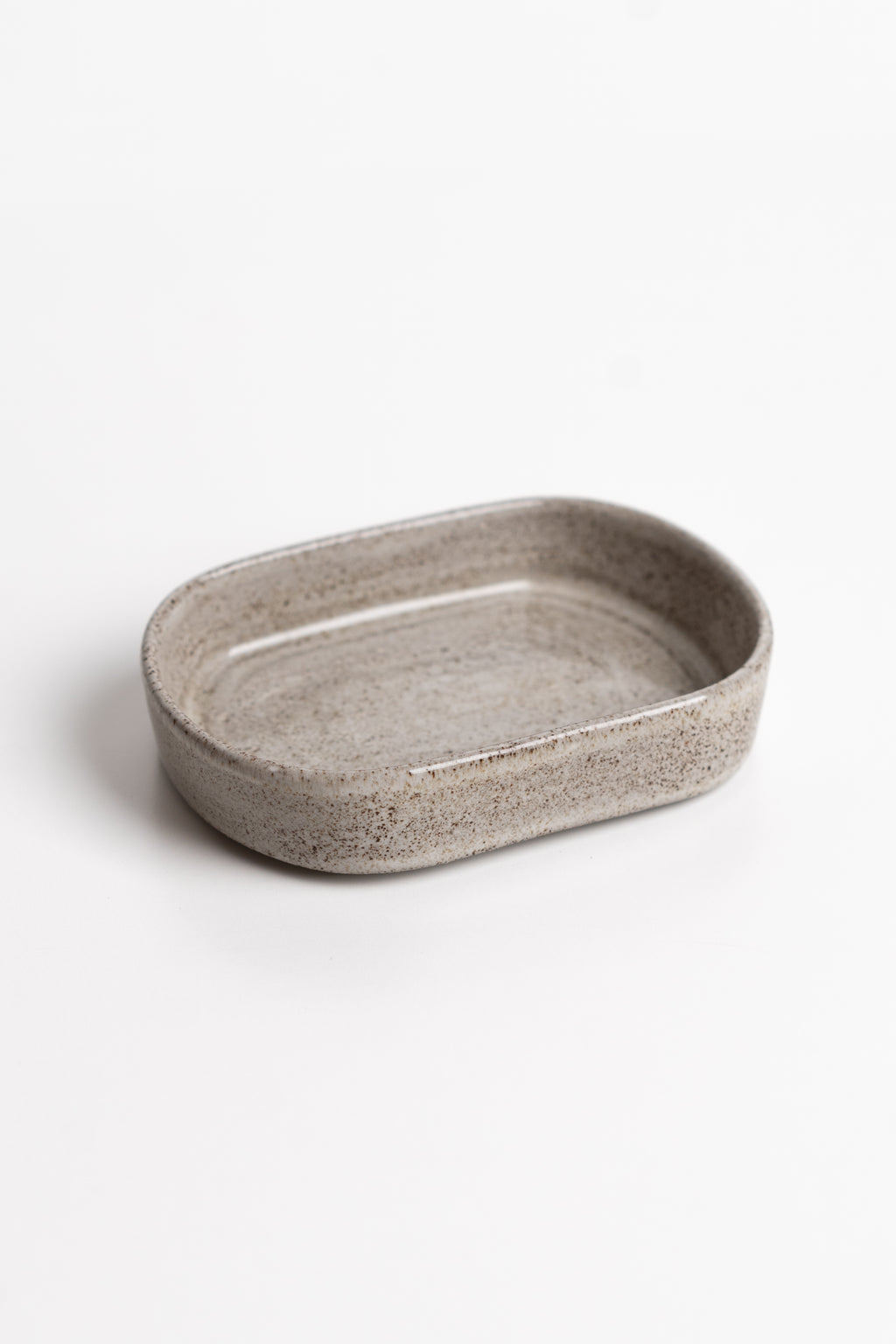 Oval ceramic dish with a textured surface on a white background