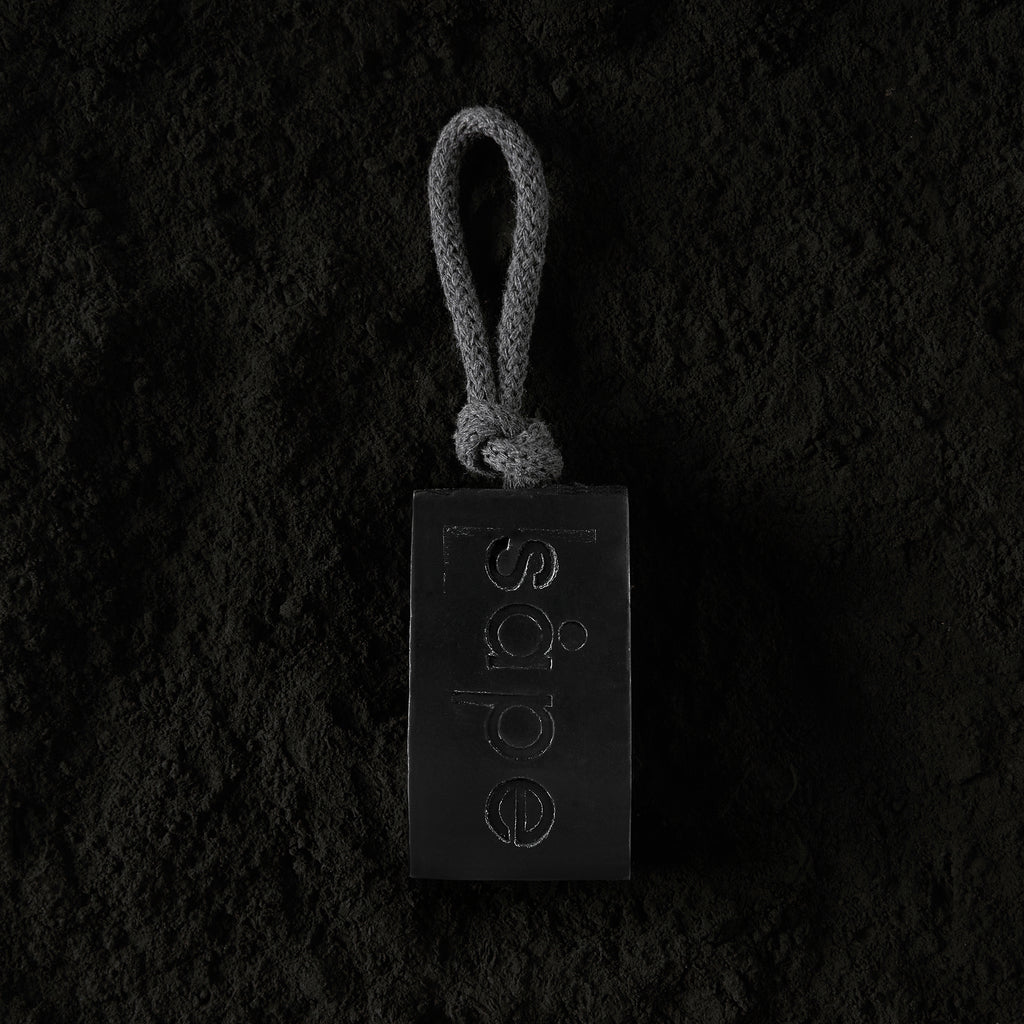 Myrk soap laying on activated charcoal – natural vegan soap on a rope UK
